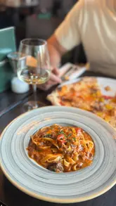 A montage-style video showcasing a variety of Italian dishes at Murati's Pizzeria, including burrata, prawns, beef rib tagliatelle, pizza, and desserts. The video focuses primarily on the food presentation and the act of eating, with minimal shots of the venue interior.