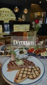 A polished montage showcasing the interior and menu of Decorum in Birmingham. The video features a variety of dishes including steak, salmon, halloumi, and desserts, alongside cocktails, set to music with location text overlays.