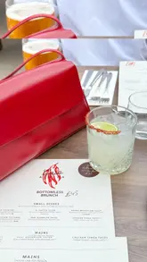 A group of friends visits a Mexican rooftop venue in London for a bottomless brunch. The video features shots of the rooftop setting, the menu, various tacos, chicken dishes, churros, and cocktails. The creators provide commentary on the experience, highlighting the quality of the food and the atmosphere.