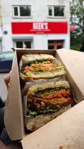 A creator reviews sandwiches from Keek's in Glasgow, eating them in their car. The video features close-up shots of the sandwiches and chips, followed by a brief look at the menu board.