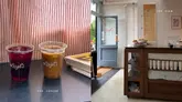 A clean, split-screen aesthetic shot showcasing a coffee shop experience. The left side features two iced drinks on a table with a newspaper, while the right side provides a view of the cafe's interior counter and service area.