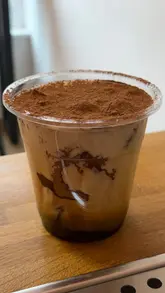 A promotional video for a coffee shop's giveaway of 100 free Tiramisu Iced Lattes, highlighting their collaboration with a roastery to support female farmers.