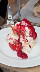 A short, high-quality clip showcasing the tableside assembly of a pavlova dessert at Brasserie Angelica, focusing on the visual appeal and theatre of the service.