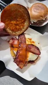 A video review of Higgsy's, a burger restaurant in Peterborough. The creator introduces the venue, shows the exterior and interior, and provides close-up shots of their signature smash burgers, loaded fries, and beer.
