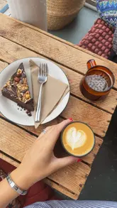 A short, aesthetic reel showcasing a visit to a combined coffee shop and bookshop in Portobello. The video features shots of the exterior, the interior book-lined walls, and a close-up of a latte and a slice of cake, emphasizing the cozy, peaceful atmosphere of the venue.