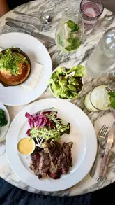 A high-quality montage showcasing Sam's Riverside restaurant, featuring shots of the exterior, interior, and a variety of plated dishes including grilled octopus, steak, and soufflé.
