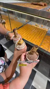 A short, handheld video showcasing a budget-friendly dessert option: ice cream topped with baklava at Shamsin Bakery in Park Royal.
