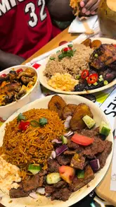 A lively review of 'Jerk vs Suya' in West Norwood, featuring a taste test of various dishes including jerk chicken, suya, and loaded fries. The video highlights the restaurant's vibrant interior, which includes arcade games and board games, and provides a positive assessment of the food quality.