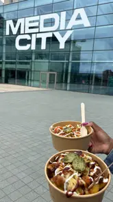 A short, upbeat vlog-style video capturing a visit to GRUB on the Docks at Media City. The video features exterior shots of the waterfront location, the container-style venue setup, and close-ups of drinks and loaded fries, conveying a relaxed, social atmosphere suitable for casual outings.