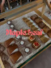 A high-angle, well-lit shot of a bakery display case filled with various pastries, including croissants and focaccia. The image effectively showcases the product range in a clean, organized manner, with natural lighting that highlights the textures of the baked goods.