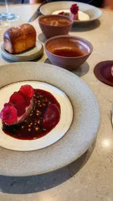 A couple visits Skof in Manchester, showcasing a high-end tasting menu experience. The video highlights the restaurant's relaxed atmosphere, the open kitchen, and several courses, including a trout tartlet, Jersey Royals, cod, duck, and a dessert.