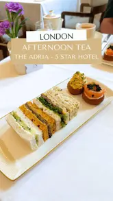 The video features a creator reviewing an afternoon tea experience at The Adria, a 5-star hotel in South Kensington, London. The content includes shots of the elegant interior, the tea selection, the food (sandwiches, scones, pastries), and champagne. The creator also suggests pairing the experience with a visit to nearby museums like the V&A and the Natural History Museum, making it a useful guide for tourists.