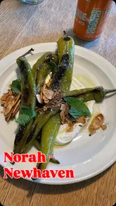 A review of Norah in Newhaven, Edinburgh, showcasing the venue's atmosphere, menu, and various dishes including asparagus, sausages, and dessert.