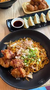 A couple visits a Japanese restaurant in Glasgow, showcasing the interior decor and a variety of dishes including ramen, gyoza, and yakisoba.