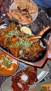 A review of Noa Asia in Watford, featuring a variety of dishes including dynamite prawns, grilled lamb chops, butter chicken, and cocktails. The video showcases the food and the restaurant's atmosphere, including sports screens.