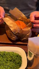 A short, punchy review of a visit to Flat Iron, featuring close-ups of their smashed onion double cheeseburger, sides like creamed spinach and mac and cheese, drinks, and their signature soft-serve ice cream.