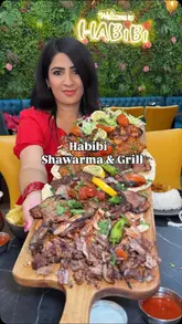A creator visits Habibi Shawarma and Grill in Manchester, showcasing their large mixed grill platter, the kitchen's charcoal grilling process, and the modern interior of the restaurant.