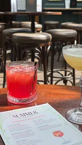 The video is a review of the new summer cocktail menu at WC, a bar in Newcastle. The creator showcases the various cocktails, highlighting their sweet-inspired flavours, and gives a tour of the venue's unique interior, which features a skylight and a history as a former men's toilet.