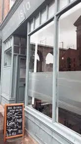 A short, montage-style reel showcasing a brunch venue called Isla in Durham. The video features quick cuts of the exterior, interior decor, menu, various drinks, and a breakfast spread, including a kids' sharing platter.