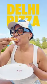 A creator reviews Delhi Pizza Club, highlighting their fusion of Indian flavours with pizza. The video features close-ups of the butter chicken pizza and keema, with the creator eating outdoors.