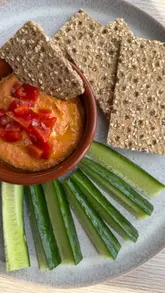 A short, instructional video demonstrating how to make roasted red pepper hummus using a food processor, showing the addition of ingredients and the final blend.