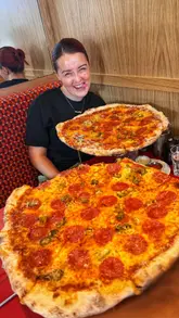 A review of Queens Diner in Glasgow, highlighting their large 14-inch New York-style pizzas and generous portions of chicken tenders.