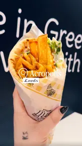 A short, punchy reel showcasing Greek street food at Acropolis in Leeds, featuring close-ups of gyros, fries, and various dips with pita bread.