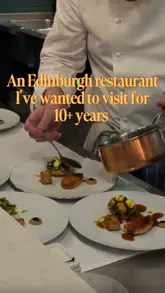 A review of a fine dining tasting menu experience at The Table in Edinburgh, highlighting the intimate chef's table setting, creative menu items like Hawaiian pizza raviolo and deep-fried Snickers, and the wine pairing option.