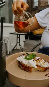 A short, aesthetic reel showcasing a visit to MAE cafe in York, featuring shots of the exterior, interior, menu, coffee, and brunch dishes like poached eggs on toast and pancakes.