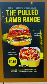 A food review video featuring a creator visiting Side Street to try their limited-time 'Pulled Lamb' range, including a lamb stacker burger, loaded lamb fries, and a brisket sandwich. The video includes shots of the exterior, interior, and close-ups of the food being eaten.