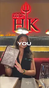 A creator visits the newly opened Gordon Ramsay's Hell's Kitchen in London, providing a review of the lunch set menu. The video features shots of the interior, the iconic red and blue kitchens, and close-ups of various dishes including the 'idiot sandwich', fish and chips, and desserts.