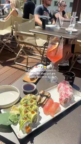A montage video showcasing a bottomless brunch experience at Sticks'n'Sushi in Manchester, featuring shots of the outdoor terrace, various sushi dishes, tempura shrimp, and cocktails.