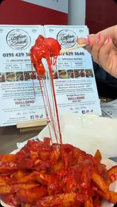 A creator reviews a takeaway venue called The Indian Snack Lunchbox, showcasing their loaded chicken tikka cheese fries, a chicken tikka kebab box, and a chicken tikka and donner pizza.