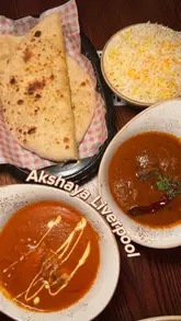 A promotional reel featuring a creator's visit to Akshaya restaurant in Liverpool. The video showcases the venue's vibrant interior, signature cocktails, and a variety of Sri Lankan and Indian dishes, including dosa tacos, tandoori broccoli, butter chicken, and lamb madras, presented in an engaging, fast-paced vlog style.