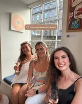 A casual, lifestyle-focused group photo of three friends enjoying glasses of rosé wine at a restaurant. The image captures a social, relaxed atmosphere, typical of a weekend recap or 'day in the life' style post.