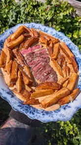 A short video showing the preparation and consumption of a steak, chips, and peppercorn sauce dish in a home setting.