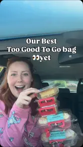 A creator reviews a 'Too Good To Go' bag from Tasty Parlour, showcasing various gluten-free and dairy-free baked goods including lemon cupcakes, almond bakewells, and Welsh cheesecakes.