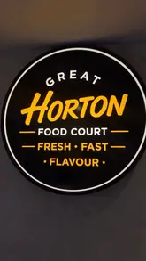 A montage-style video showcasing the various food vendors at the Great Horton Food Court in Bradford, including shots of the exterior, signage, and close-ups of food items like brisket toasties, pizza, and smoothies.
