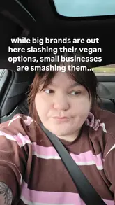 The video features a creator visiting a vegan market or event, showcasing various plant-based food vendors including donut stalls, brownie sellers, a vegan fish and chip stand, and chocolate brands.