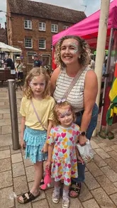 A montage video showcasing the Waterside Summer Festival in Stratford-upon-Avon, highlighting various market stalls, food vendors, and family-friendly activities like face painting and lawn games.