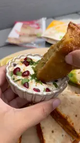 A short video showcasing an Indian-inspired sharing board created using 'Tuk In' pre-packaged food products, including various samosas and 'Curry in a Naan' items, served with chutneys.