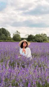 The video features a creator walking through and posing in a large, vibrant lavender field, highlighting the aesthetic appeal of the location as a summer day trip destination near London. It uses slow-motion shots and soft music to create a relaxing, aspirational atmosphere.