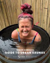 A high-quality, engaging portrait of a woman sitting in a wooden sauna tub, used to promote a magazine feature on urban sauna culture in Glasgow. The image effectively captures the 'wellness' experience.