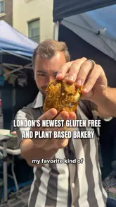 A creator visits Chapter Eight, a gluten-free and plant-based bakery stall at Berwick Street Market in London. The video features the owner, Manny, and highlights various cookies and brownies available for purchase.