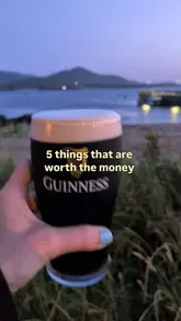 A short, aesthetic montage featuring a hand holding a pint of Guinness in various outdoor settings across Ireland, including beachside, harbour, and beer garden locations. The video uses a listicle format to highlight the experience of enjoying a pint in different scenic environments.