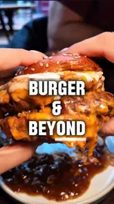 A couple visits the new Burger & Beyond location in Brighton, showcasing a variety of dishes including corn ribs, steak tartare, bone marrow gravy fries, a double patty burger, rib eye steak, and a Biscoff S'mores brownie, paired with English sparkling wine and cocktails.