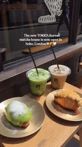 A short, aesthetic montage showcasing the opening of TOKKIA, a new Korean matcha house in Soho, London. The video features close-up shots of matcha and hojicha lattes being prepared, alongside various salt bread pastries displayed on a counter.