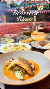 A promotional reel for Brasserie Blanc in Manchester, featuring a montage of the restaurant's interior, specifically its glass atrium, alongside close-ups of various French dishes and cocktails. The video uses smooth transitions and high-quality footage to create an inviting atmosphere.
