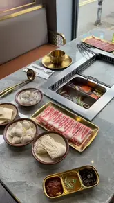 A review of Sizzle in Glasgow, showcasing the all-you-can-eat Korean BBQ and hotpot experience. The video demonstrates the ordering process, the sauce station, the buffet selection, and the cooking of raw ingredients at the table.
