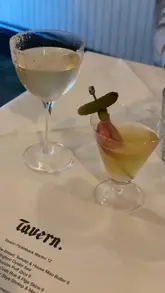 A short, fast-paced video showcasing a variety of dishes and drinks at Tavern, a candlelit restaurant. The video features close-up shots of the menu, cocktails, oysters, small plates, and main courses, providing a quick overview of the dining experience.